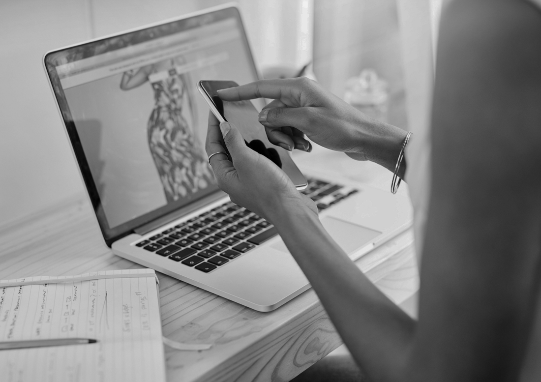 Small business owner reviewing website design on laptop and smartphone at a workspace